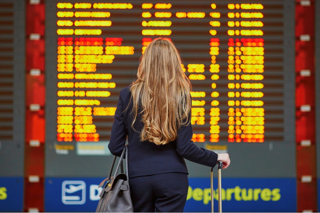 A woman at the airport consulting the flight times.