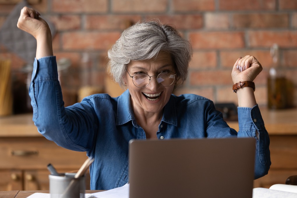 An investor is all smiles after lending securities or shares from her computer.
