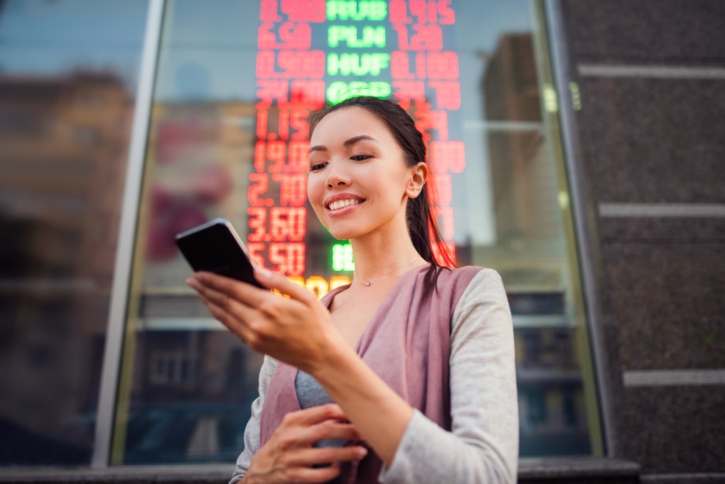 A young woman using her cellphone to consult her investments in the stock market