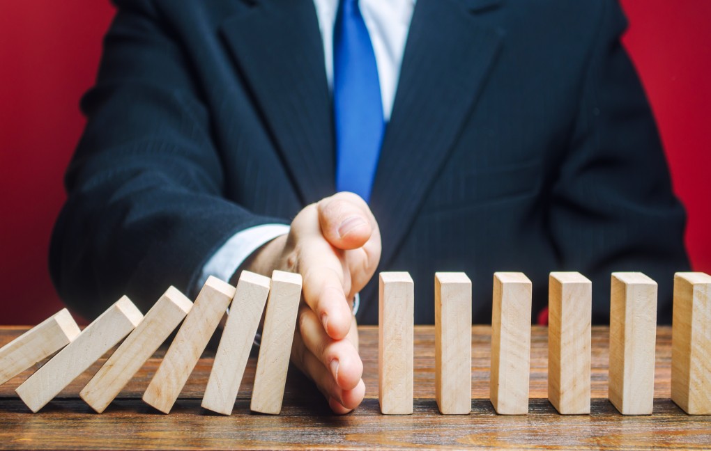 A man putting his hand in between blocks to prevent them from falling.