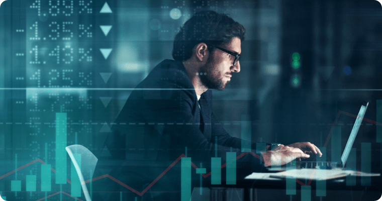 Photo of a man in front of their computer with charts superimposed on the image