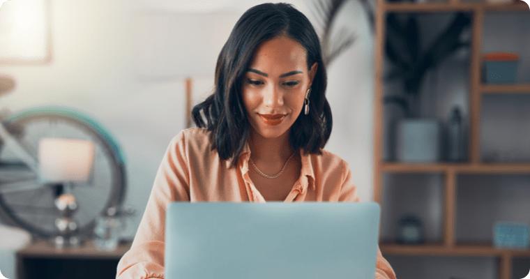 Photo of a woman working on their laptop in their living room
