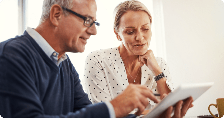 Photo of a couple looking at their tablet in their kitchen
